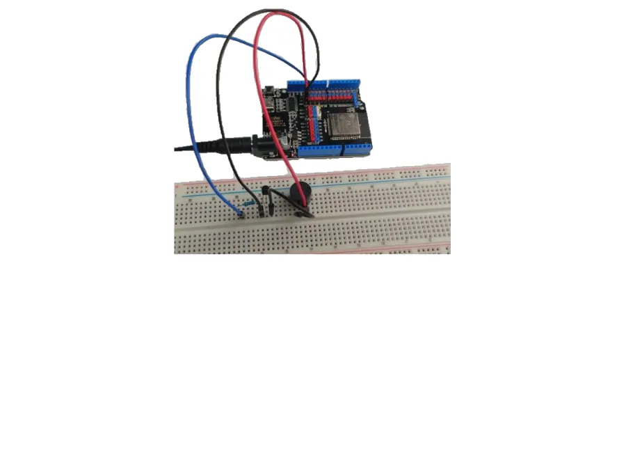 תצלום של המעגל הבנוי: לוח ESP32 מחובר בחוטים לזמזם ולטרנזיסטור על לוח הניסוי