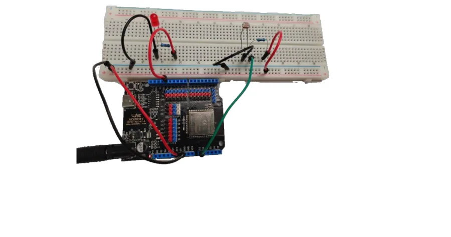 המעגל המורכב — לוח ESP32, נורית וחיישן אור על לוח הניסוי