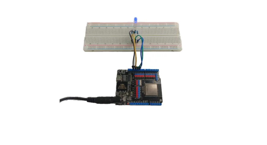 לוח ESP32 מחובר ללוח ניסוי, נורית RGB מאירה בכחול