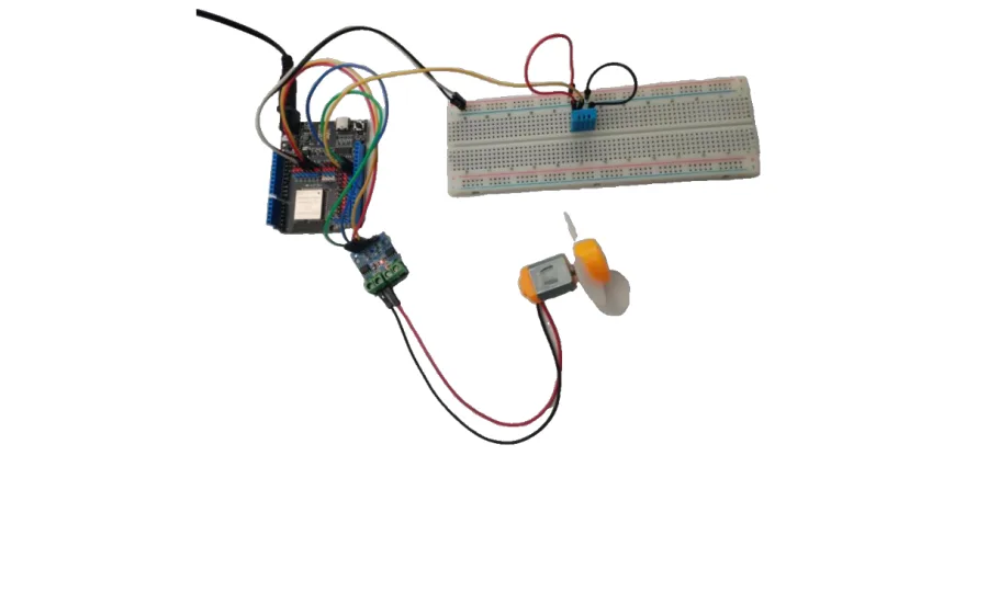 המערכת המורכבת במציאות: לוח ESP32 מחובר בחוטים צבעוניים לברדבורד עם חיישן DHT11 כחול, ולמטה מודול הנעה ומנוע עם מדחף לבן
